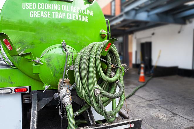 a grease trap being pumped by a sanitation technician in Bee Cave